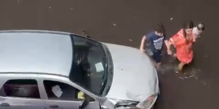 Flagra! Mulher tenta salvar carro de alagação com bebê no colo durante forte chuva