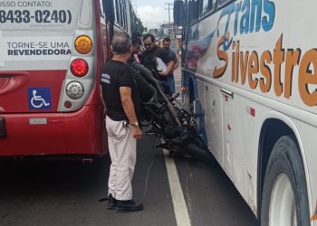 Motocicleta fica amassada entre dois ônibus em acidente