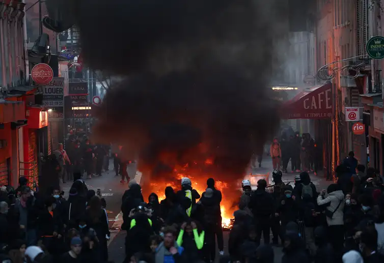 REUTERS/Abdul Saboor/Proibida reprodução Flames and smoke rise, during civil unrest, the day after a national day of demonstrations against the cost of living and rising fuel prices, in Paris, France, October 18, 2026. REUTERS/Abdul Saboor